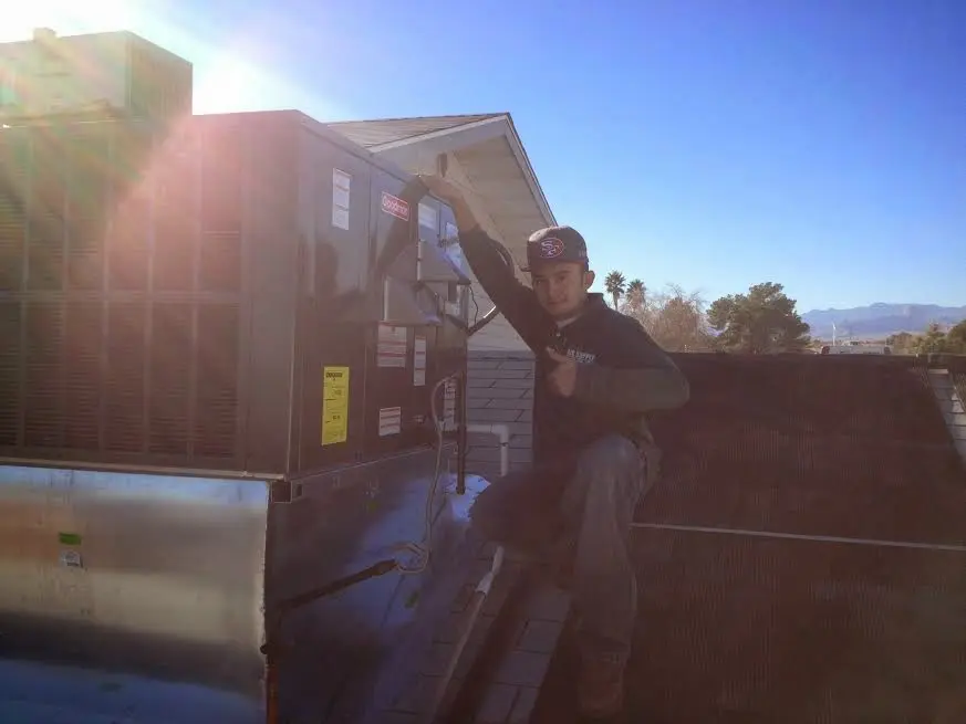 HVAC technician performing Air Duct Cleaning on a rooftop unit in Rockwood